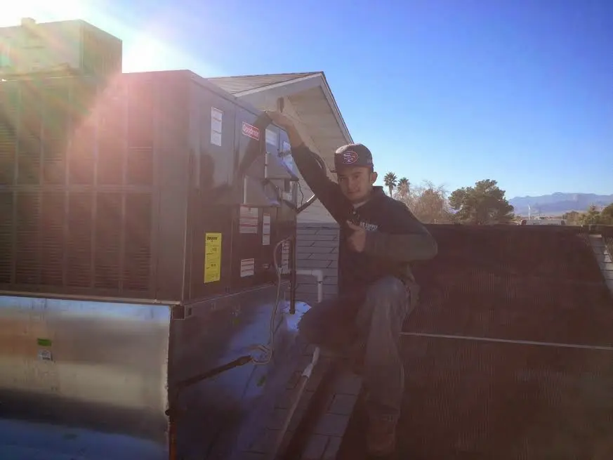 HVAC technician performing Air Duct Repair on a rooftop unit in Dacula